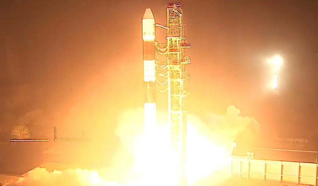 A rocket on the launchpad, adorned with the ISRO logo, ready for liftoff under sky.