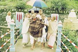 The serene Kainchi Dham temple surrounded by lush green hills, with the Kosi River flowing nearby. In the foreground, a portrait of Baba Neem Karori (Maharajji), radiating divine grace and presence, capturing the spiritual essence of the ashram