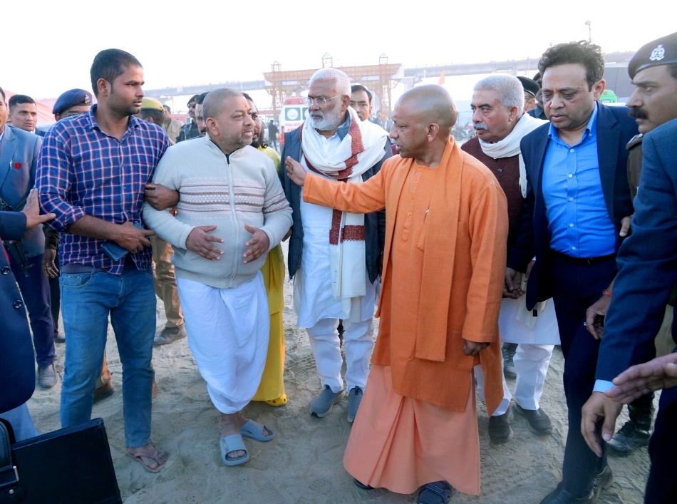 Firefighters battling a large fire at the Maha Kumbh 2025 site, with CM Yogi Adityanath inspecting the scene alongside senior officials.