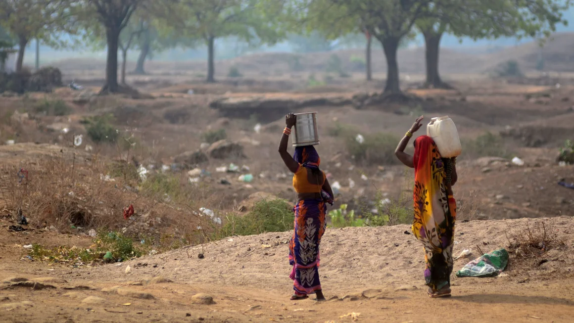 Indian women carrying drinking water from a municipal water tanker
