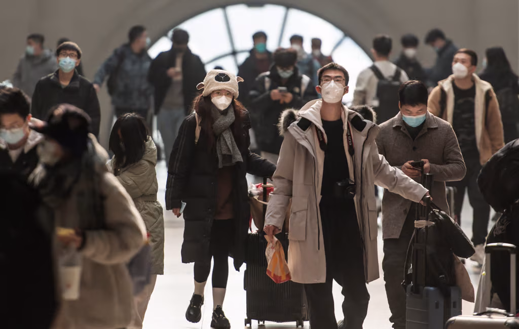 This photo taken on December 10, 2022 shows passengers wearing face masks amid the Covid-19 pandemic arriving at Hankou Railway Station in Wuhan in China's central Hubei province. | STR/AFP via Getty Images