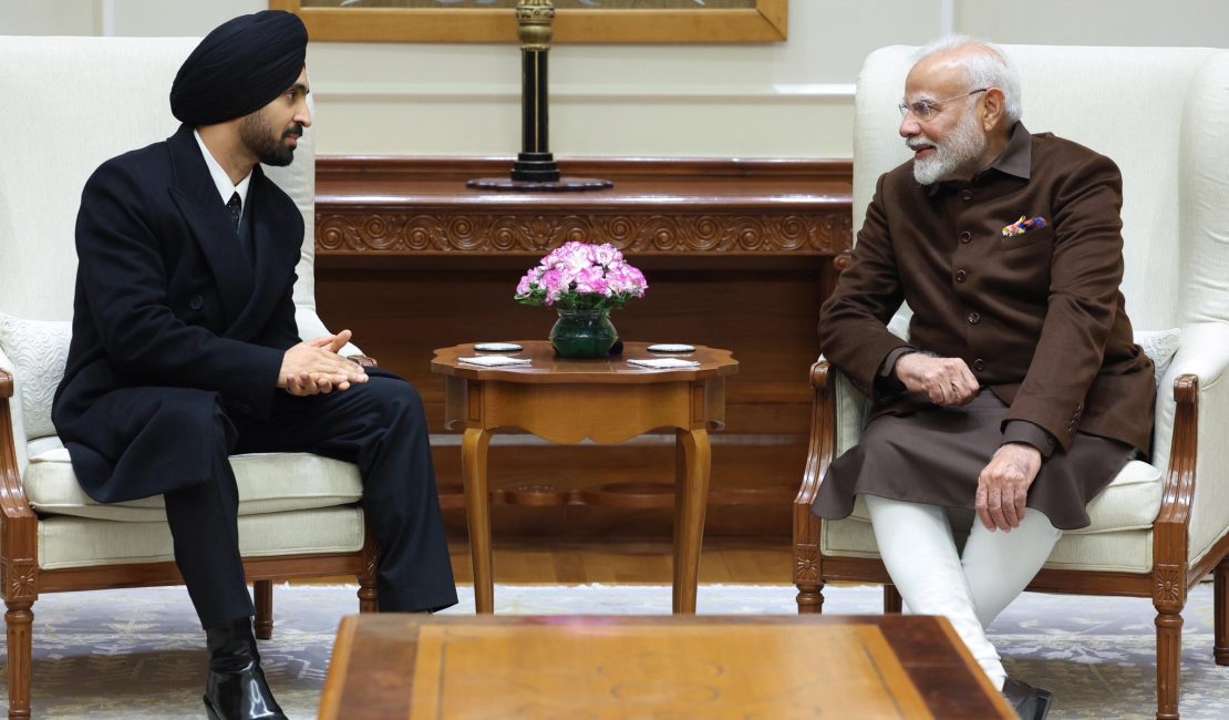Diljit Dosanjh and PM Modi sharing a musical moment during their meeting in Delhi, with Diljit singing and PM Modi tapping beats on the table