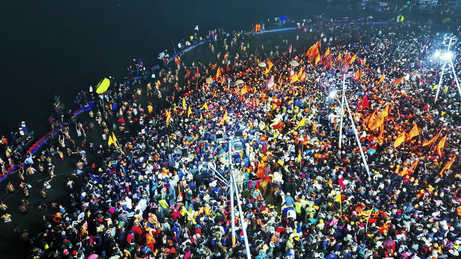 Thousands of devotees immersed in the sacred waters of the Triveni Sangam, performing rituals during the First Amrit Snan of Mahakumbh 2025.