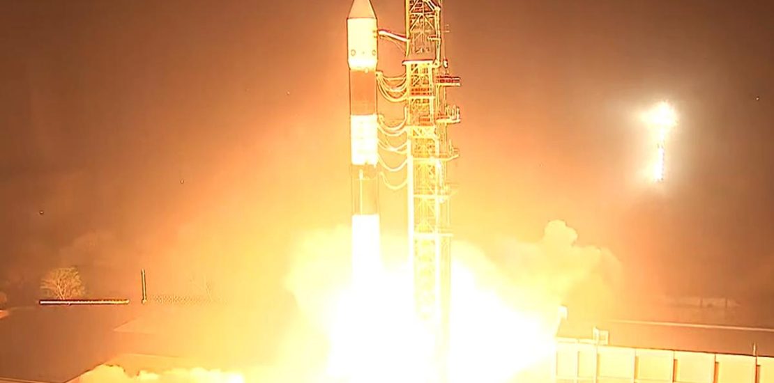 A rocket on the launchpad, adorned with the ISRO logo, ready for liftoff under sky.