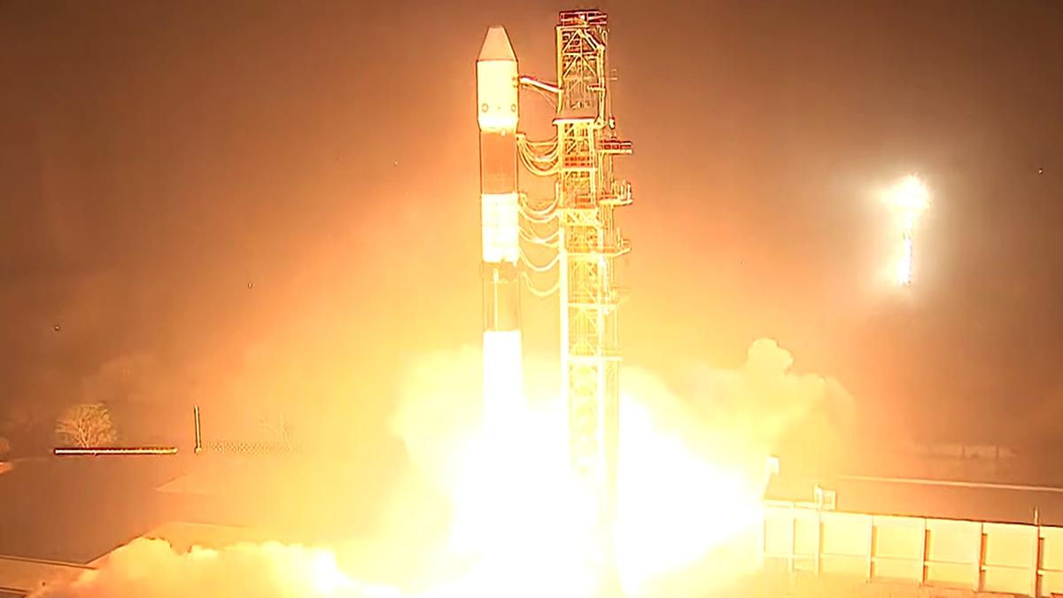 A rocket on the launchpad, adorned with the ISRO logo, ready for liftoff under sky.