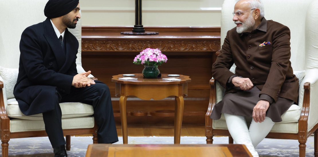Diljit Dosanjh and PM Modi sharing a musical moment during their meeting in Delhi, with Diljit singing and PM Modi tapping beats on the table