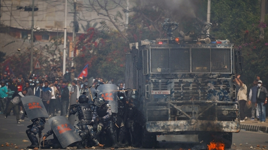 Riot police personnel take cover from stones hurled by pro-monarchist demonstrators during a protest demanding the restoration of Nepal's monarchy, which was abolished in 2008, saying the governments have failed to make any significant changes, in Kathmandu, Nepal, (Reuters)
